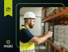 Operador logístico utilizando coletor de dados para estoque Moki para registrar movimentação de palete em armazém organizado.
